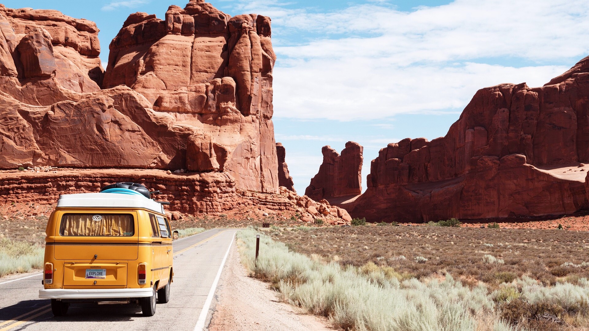 A Yellow Van Driving Down A Desert Road Zoom Backgrounds Template